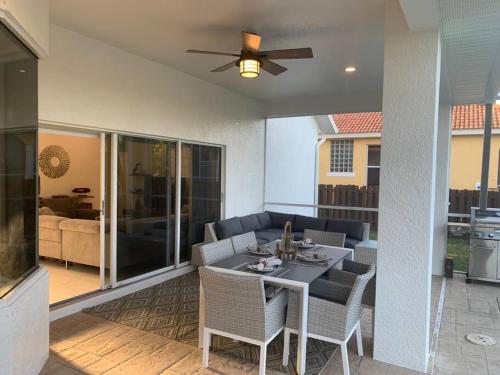 a patio with a table with chairs and a ceiling fan at AAA - Marco Island Luxury Home, Walk To The Beach. in Marco Island