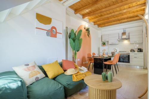 ein Wohnzimmer mit einem grünen Sofa und einer Küche in der Unterkunft [Piazza Maggiore] Il Sentiero - Villa with garden in Bologna