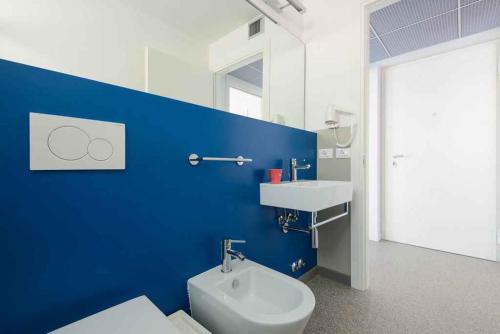 La salle de bains bleue est pourvue de toilettes et d'un lavabo. dans l'établissement Apartment in Lignano Sabbiadoro 21778, à Lignano Sabbiadoro