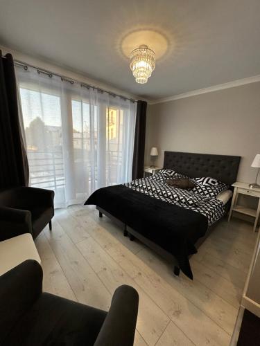 a bedroom with a bed and a chandelier at Saviano Mare Villa in Międzyzdroje