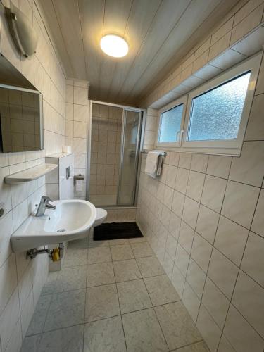 La salle de bains est pourvue d'un lavabo et d'une douche. dans l'établissement Ferien- und Monteurswohnung in Amstetten, 