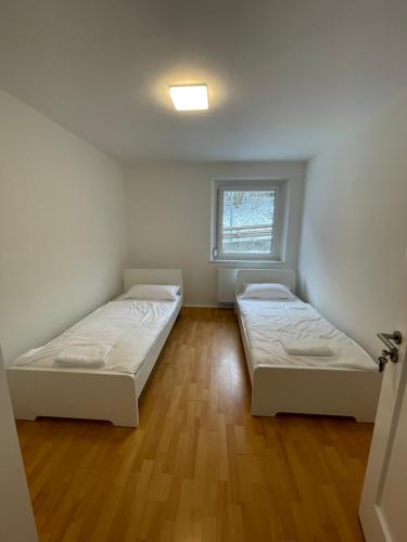 two beds in a small room with a window at Ferien- und Monteurswohnung in Amstetten 