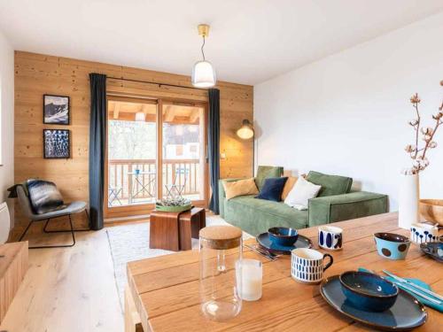- un salon avec une table et un canapé vert dans l'établissement Appartement 3 Ch., 4 Pièces, 6 Pers., Valmorel avec Parking - FR-1-291-887, à Valmorel