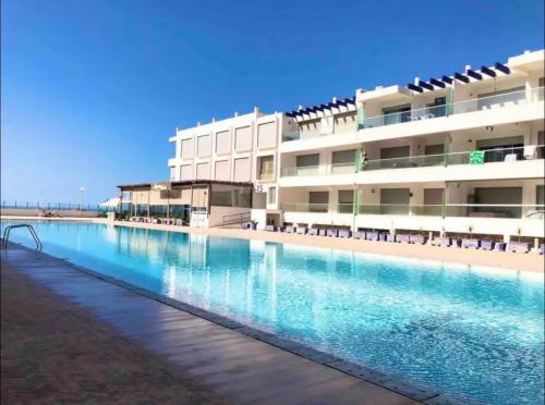 a large swimming pool in front of a building at Superbe appartement pieds dans l’eau in Aourir