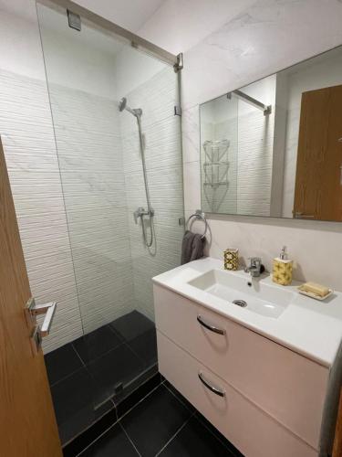 a bathroom with a sink and a shower at Superbe appartement pieds dans l’eau in Aourir