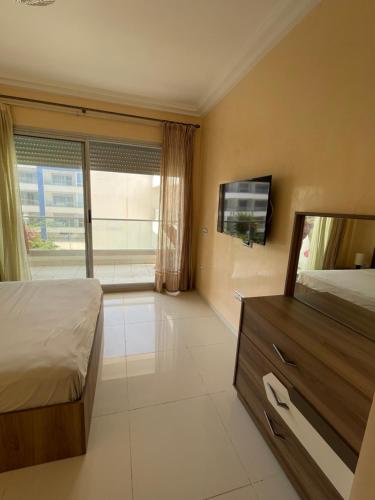 a bedroom with a bed and a flat screen tv at Superbe appartement pieds dans l’eau in Aourir