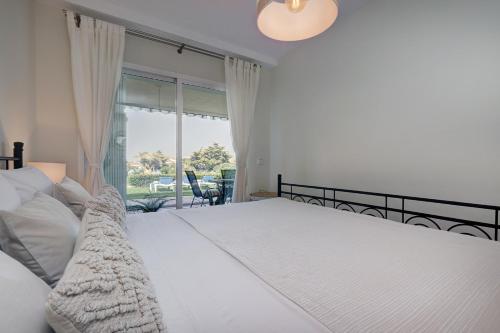 - une chambre avec un grand lit blanc et une fenêtre dans l'établissement La Cala gorgeous 2 bedroom apartment with stunning gardens, pools and sea views, à Mijas