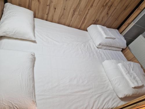 a bed with white sheets and pillows on it at Gent Apt in Vienna