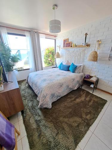 a bedroom with a large bed and a large window at La Marina home in Concón