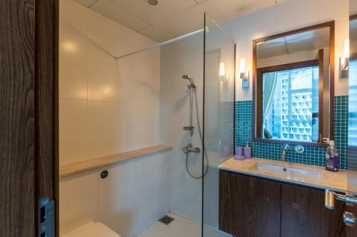 a bathroom with a shower and a sink at 3BR Oasis on Palm with Sea View, Private beach and Lazy River Access in Dubai