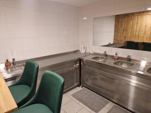 a bathroom with two sinks and two green chairs at Gent Apt in Vienna