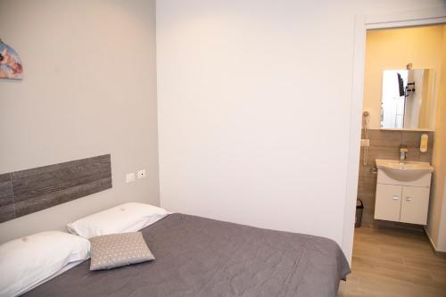 a small bedroom with a bed and a sink at Leon D'Oro in Corleone