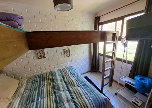 a bunk bed in a room with a ladder at La Marina home in Concón