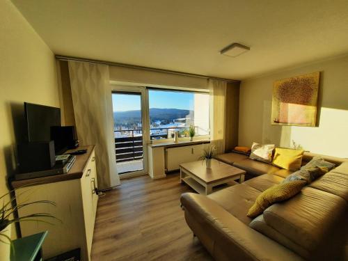 a living room with a couch and a large window at Appartement 13 im Haus Dreisessel in Haidmühle