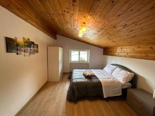 1 dormitorio con cama y techo de madera en Luxury Apartment on the mountains Wi-fi - Parking, en Tarvisio