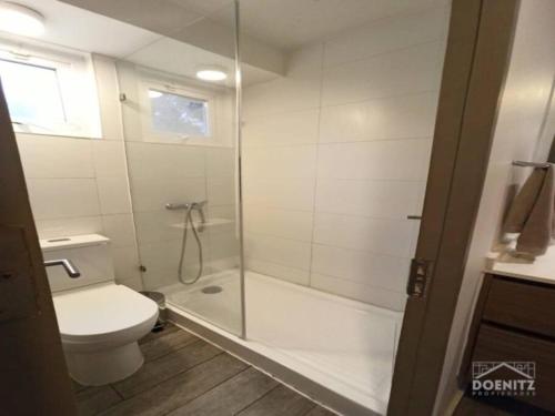 a bathroom with a toilet and a glass shower at Moderno y equipado estudio en Los Dominicos in Santiago