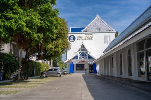 a building with a car parked in front of it at Singharaj Boutique Hotel in Chiang Mai