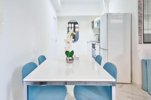 ein Esszimmer mit einem weißen Tisch und blauen Stühlen in der Unterkunft Beautiful Appartment 6 Peoples in Montrouge