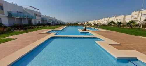 uma fila de piscinas em frente a alguns edifícios em Premium Holidays - Modern holiday home with pool nearby Vistabella Golf em Orihuela