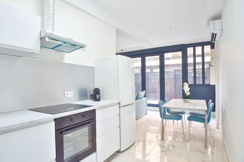 une cuisine avec des comptoirs blancs, une table et des chaises dans l'établissement Beautiful Appartment 6 Peoples, à Montrouge