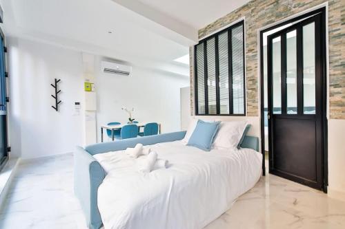 ein großes weißes Bett in einem Zimmer mit Ziegelwand in der Unterkunft Beautiful Appartment 6 Peoples in Montrouge