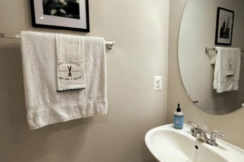 uma casa de banho com lavatório, espelho e toalhas em New 3BR condo near IAD airport weekly and monthly discount em Herndon
