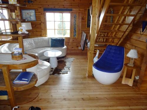 ein Wohnzimmer mit einem Sofa und einer Badewanne in einer Hütte in der Unterkunft véritable chalet finlandais in Basse-sur-le-Rupt