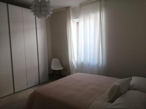 a bedroom with a white bed and a window at Maresol apartment in Carrara