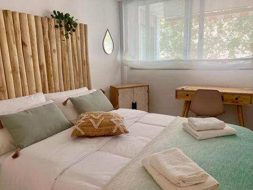 1 dormitorio con 1 cama blanca, escritorio y ventana en Dolce Terrassa 25 min Barcelona and Beach, en Terrassa