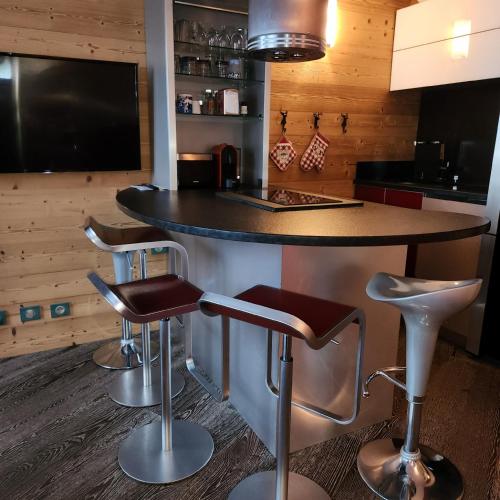 une cuisine avec un comptoir et des tabourets de bar dans l'établissement Terrasses du Morel - A17 - Appart 5 pers, à Doucy