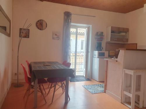 une cuisine avec une table et des chaises dans une pièce dans l'établissement Appartement meublé centre ville NYONS, à Nyons