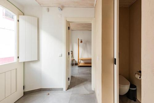 a bathroom with white walls and a toilet at Casa elegante em Vila tranquila in Barão de São Miguel