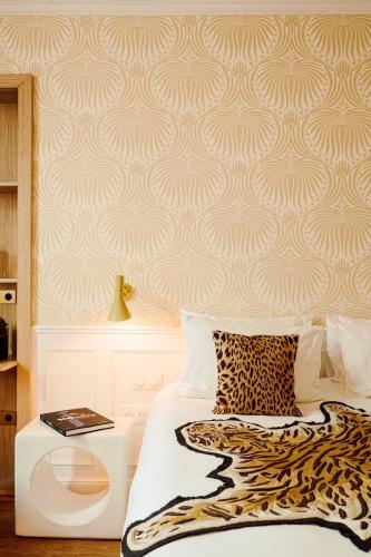 a bedroom with a bed with a patterned wall at Hôtel Thoumieux in Paris