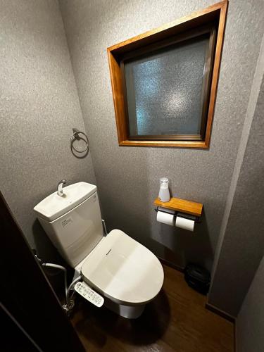 a bathroom with a white toilet and a window at AYA-KAMOJIMA in Yoshinogawa