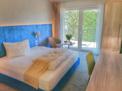 a bedroom with a large bed and a large window at Green Business Hotel am Mühlengrund Graz in Graz