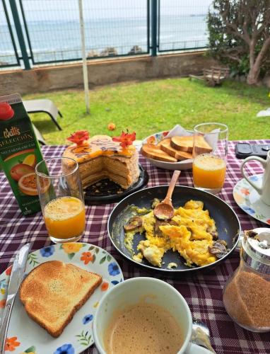 a breakfast table with eggs and toast and orange juice at La Marina home in Concón