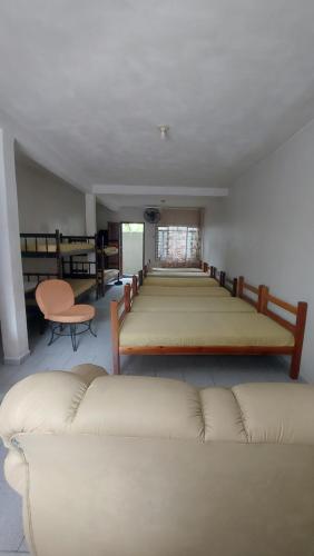瓜拉圖巴的住宿－Pousada Maringá，配有一张大床和一张沙发的房间