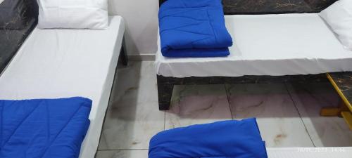 two beds with blue pillows on them in a room at Murlidhar Homestay in Garudeshwar