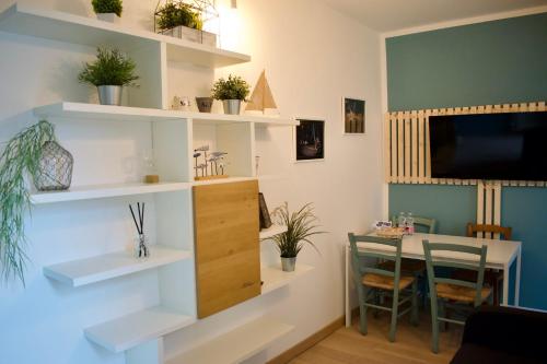 Le Camere di Olivia في رافينا: غرفة معيشة مع رفوف بيضاء وطاولة