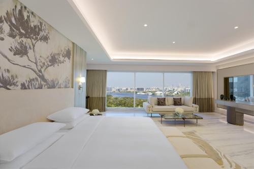 a bedroom with a large bed and a living room at Grand Hyatt Dubai in Dubai