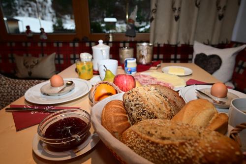 a table with a plate of bread and apples and eggs at ZIRBENNEST Martha in Biberwier