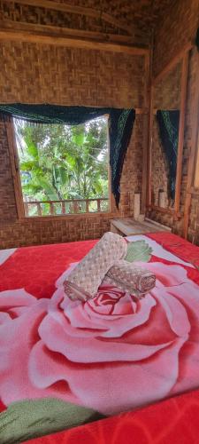um quarto com uma grande cama vermelha e uma janela em Tetebatu Hostel Private Bungalow em Tetebatu