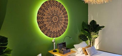 a room with a green wall with a surfboard on it at epicenter LAGOA in Lagoa