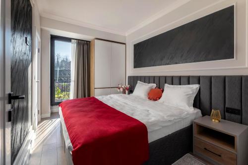 - une chambre avec un grand lit et une couverture rouge dans l'établissement LUNA RESIDENCE, à Altınova