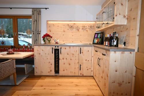 a kitchen with wooden cabinets and a counter with a table at ZIRBENNEST Martha in Biberwier