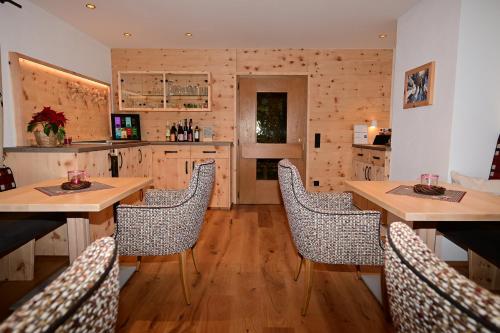 a kitchen with wooden floors and wooden tables and chairs at ZIRBENNEST Martha in Biberwier
