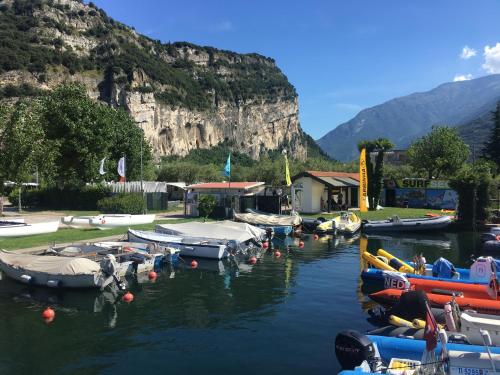 a group of boats are docked in the water at Outdooredo Garda Torbole in Nago-Torbole