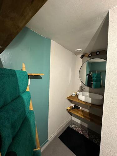 La salle de bains est pourvue d'un miroir et de serviettes vertes. dans l'établissement Studio indépendant avec jardin, à Tours
