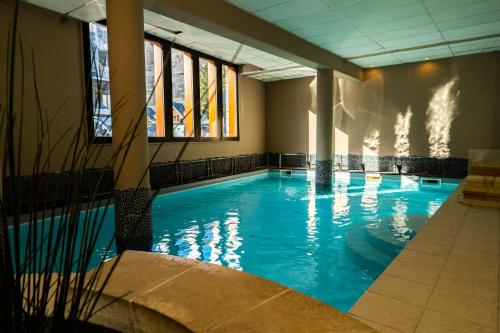 - une grande piscine d'eau bleue dans un bâtiment dans l'établissement Résidence Cami Réal ****, à Saint-Lary-Soulan