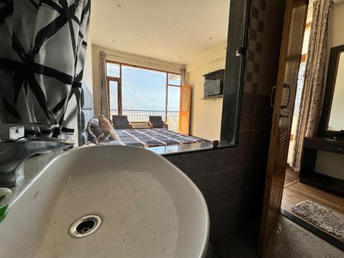 a bathroom with a tub with a view of the ocean at Nomad Bed & Breakfast in Manāli